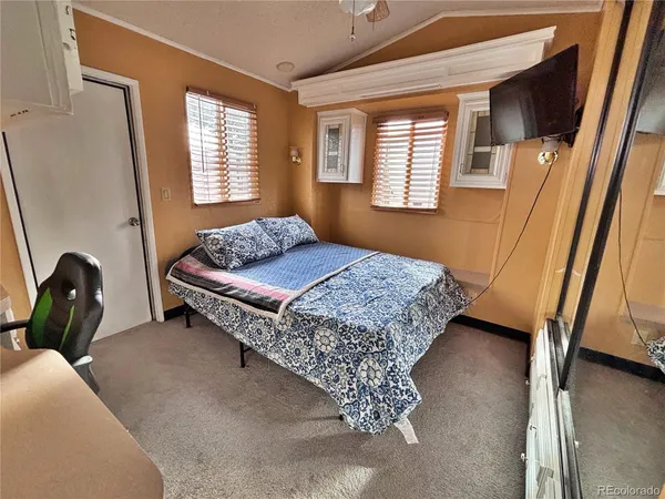 a bedroom with a bed and a dresser next to a window