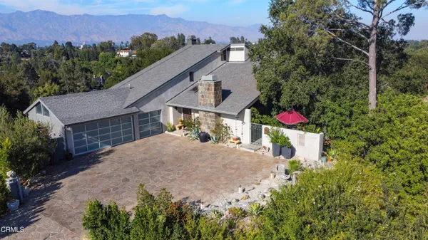 a view of a house with a yard and a car park