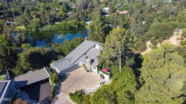 an aerial view of a house with a yard and lake view