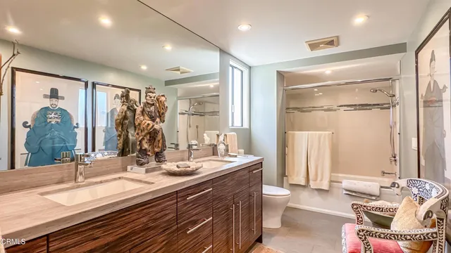 a bedroom with a bed a chandelier and dresser