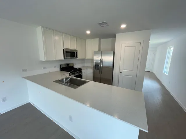 a kitchen with stainless steel appliances a refrigerator sink and microwave