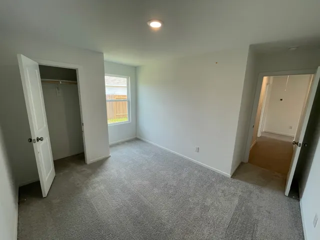 an empty room with windows and closet