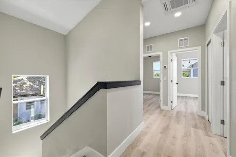 a view of hallway with stairs and wooden floor