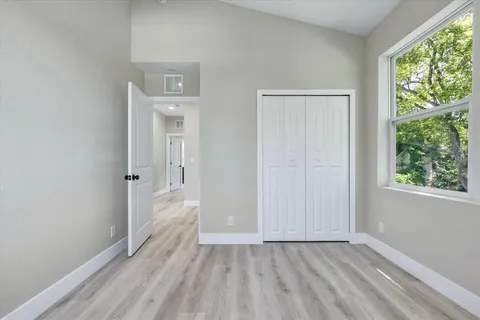 an empty room with wooden floor and windows