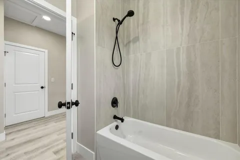 a bathroom with a bath tub with a shower