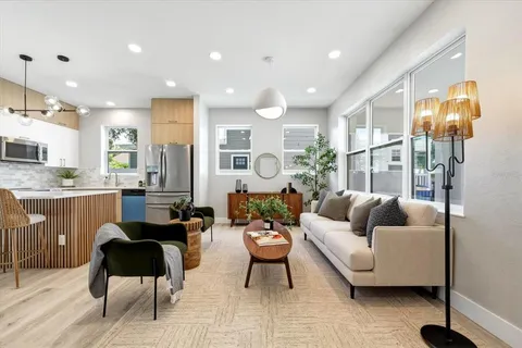 a living room with furniture kitchen and a chandelier