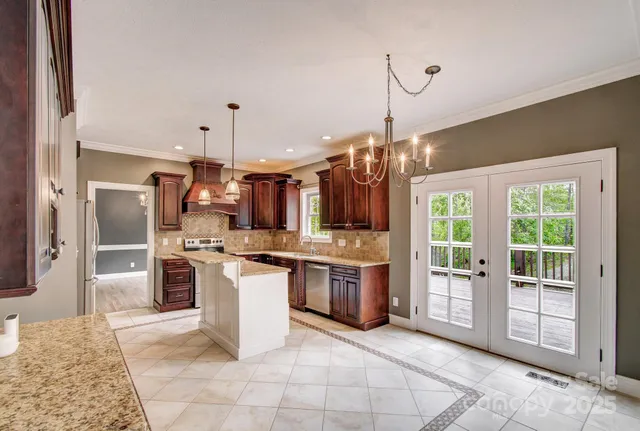 a large kitchen with kitchen island a large counter space appliances and cabinets