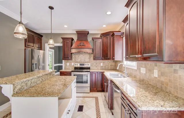 a kitchen with stainless steel appliances granite countertop sink stove and refrigerator