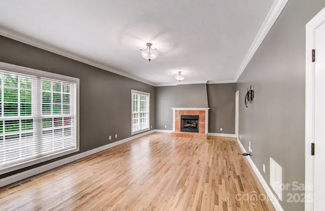 a view of empty room with wooden floor and fireplace