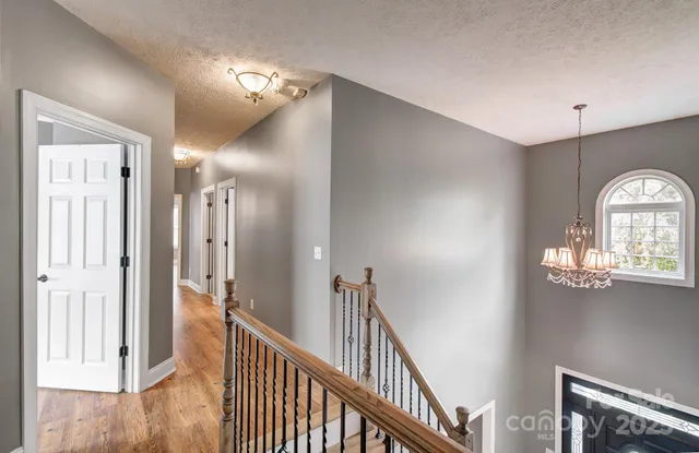 a view of a hallway with windows and chandelier