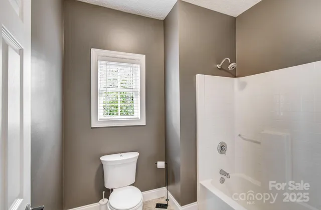 a bathroom with a toilet a sink and shower