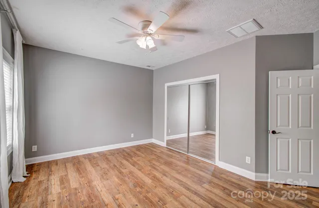 an empty room with closet and windows