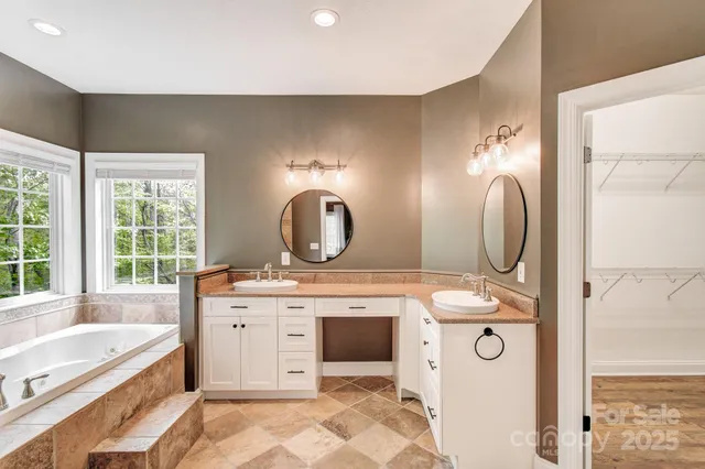 a spacious bathroom with a granite countertop sink and a mirror