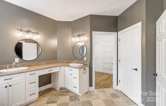 a bathroom with a double vanity sink mirror and shower