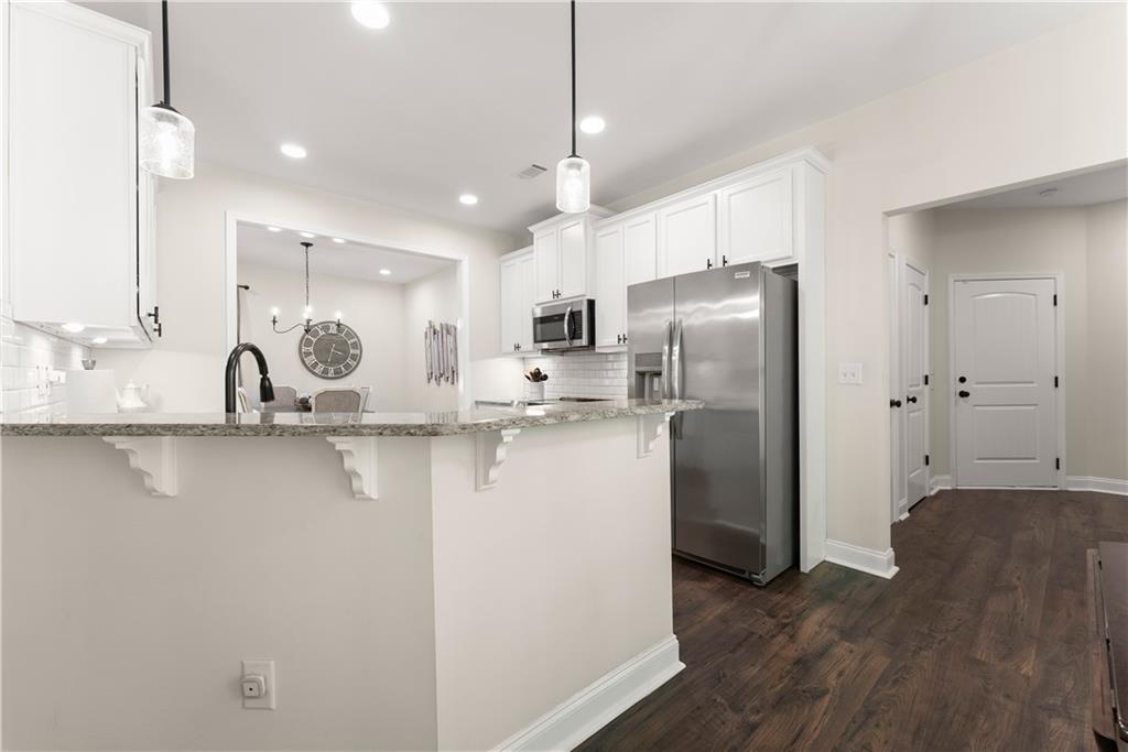 179 Prime Drive Commerce, GA 30530 - Photo 11 of 44 a kitchen with stainless steel appliances granite countertop a refrigerator a sink a stove and oven with wooden floor