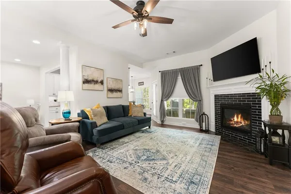 a living room with furniture a fireplace and a flat screen tv