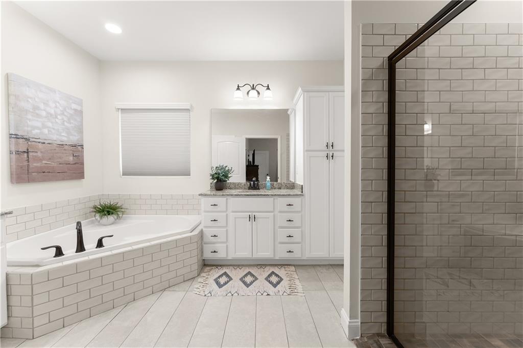179 Prime Drive Commerce, GA 30530 - Photo 24 of 44 a bathroom with a bathtub sink and mirror