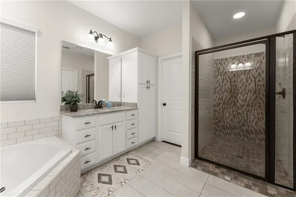 a bathroom with a tub a sink and mirrors
