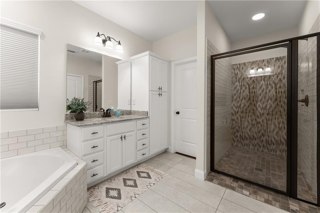 179 Prime Drive Commerce, GA 30530 - Photo 25 of 44 a bathroom with a tub a sink and mirrors