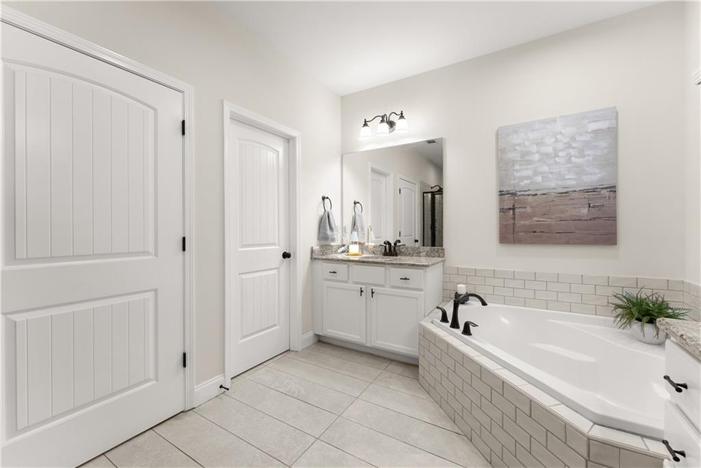 179 Prime Drive Commerce, GA 30530 - Photo 26 of 44 a bathroom with a tub a sink and mirror