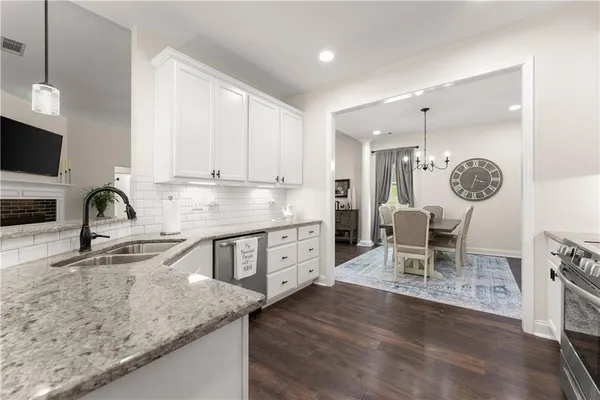 a kitchen with granite countertop a sink cabinets and stainless steel appliances