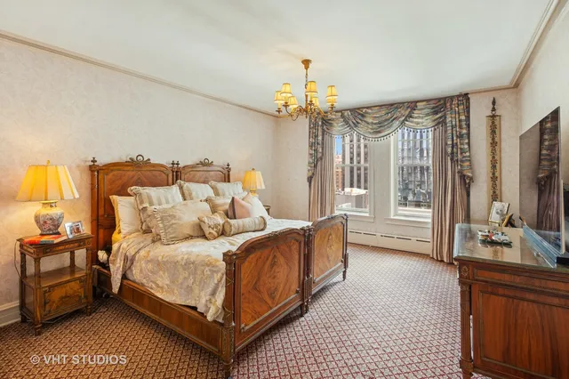 a bedroom with a bed couch and a flat tv screen