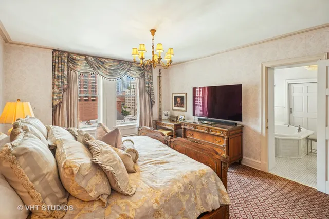 a spacious bedroom with a bed and a flat screen tv