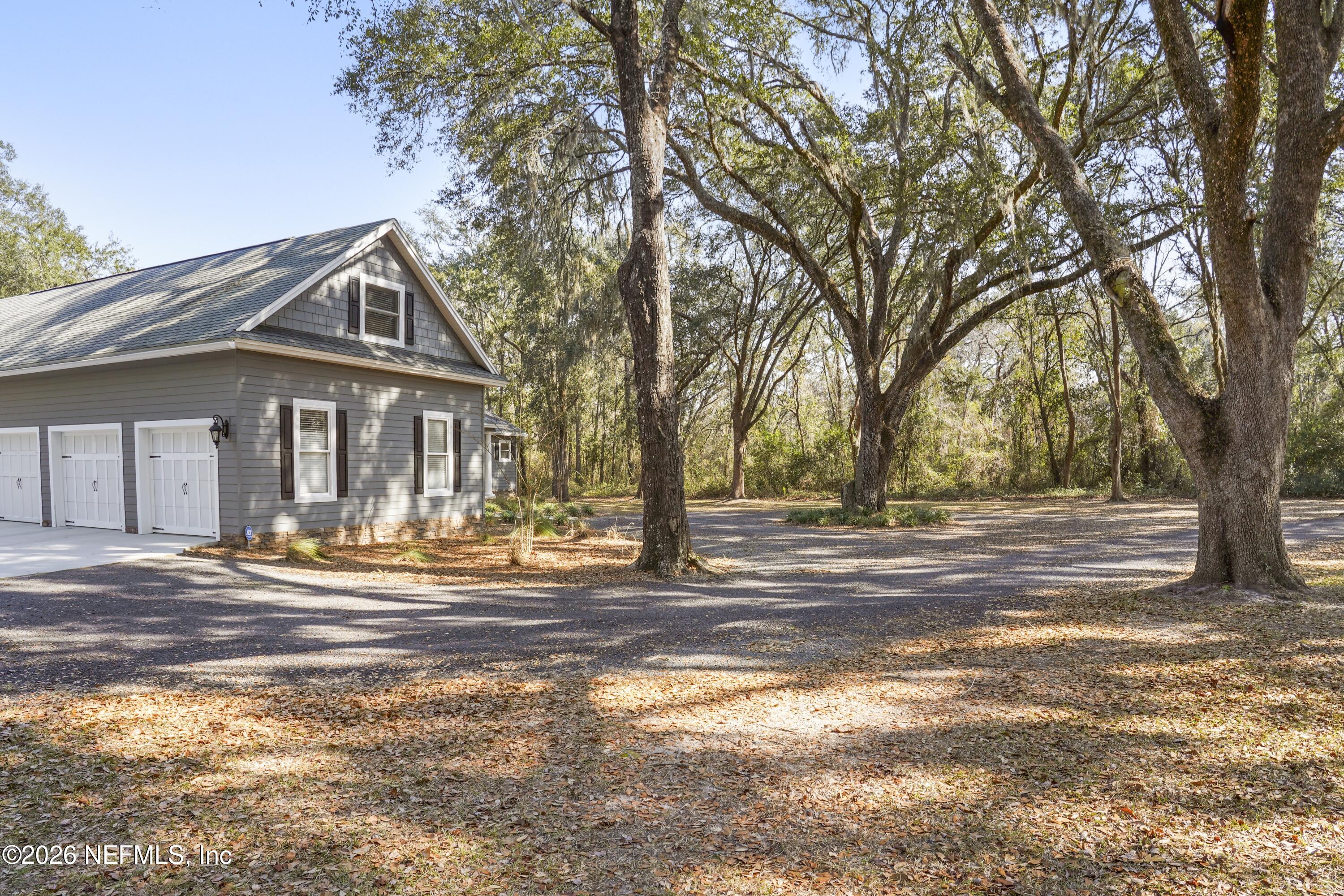 6153 Tim Crews Road Macclenny, FL 32063 - Photo 21 of 79 a front view of residential houses with yard and trees