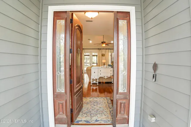 a living room with furniture a chandelier and a flat screen tv