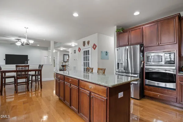 a bathroom with a granite countertop toilet sink and mirror