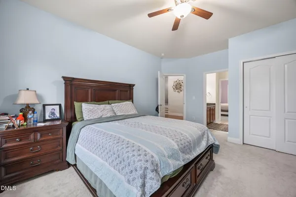 a spacious bedroom with a bed a chandelier and a window