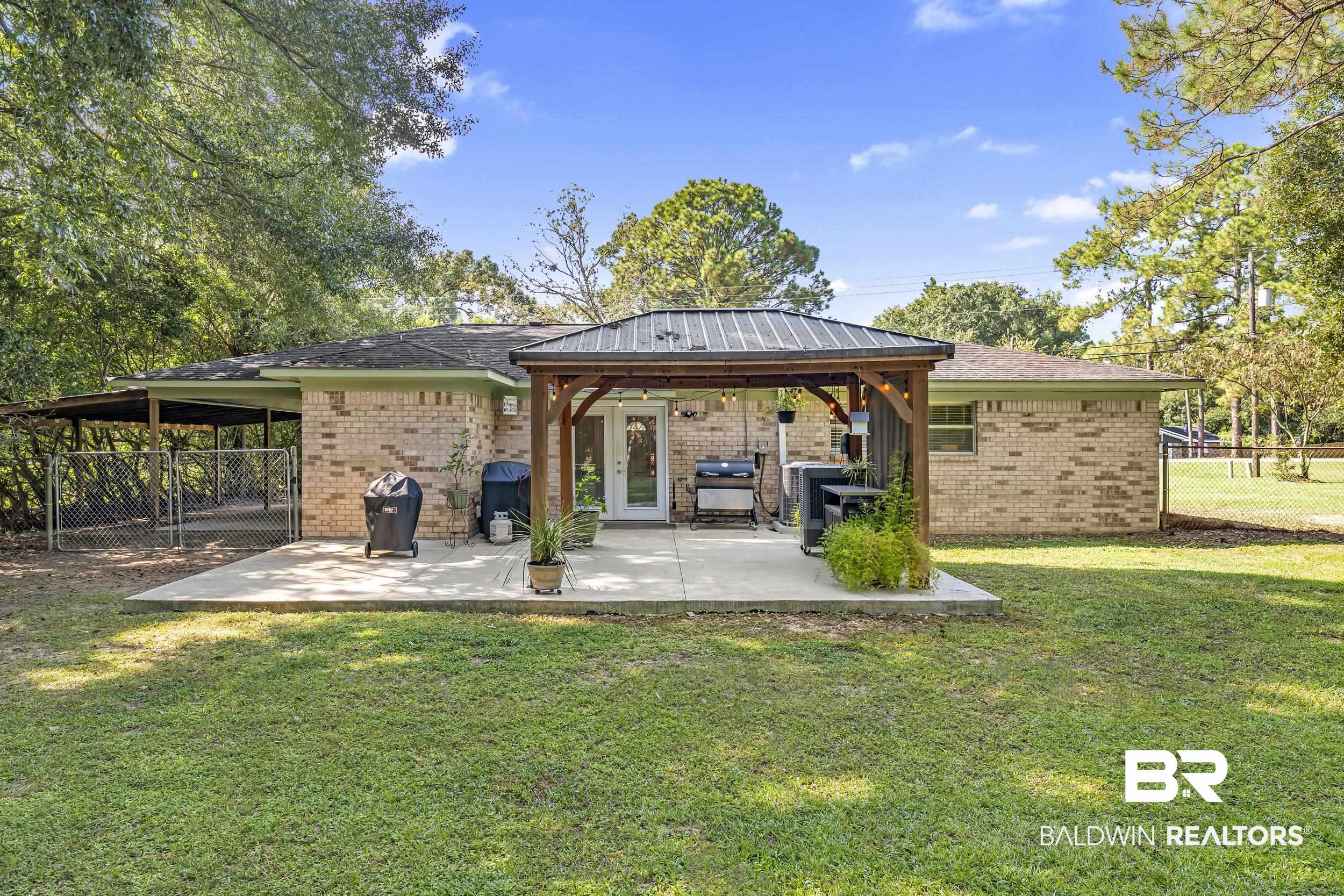 9660 Howells Ferry Road Semmes, AL 36575 - Photo 7 of 23 Rear view of house with a patio area, a gazebo, and brick siding