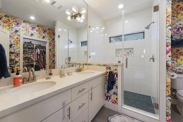 a bathroom with a sink vanity mirror and shower