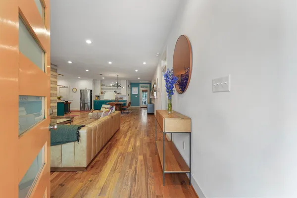 a view of a living room with kitchen and wooden floor