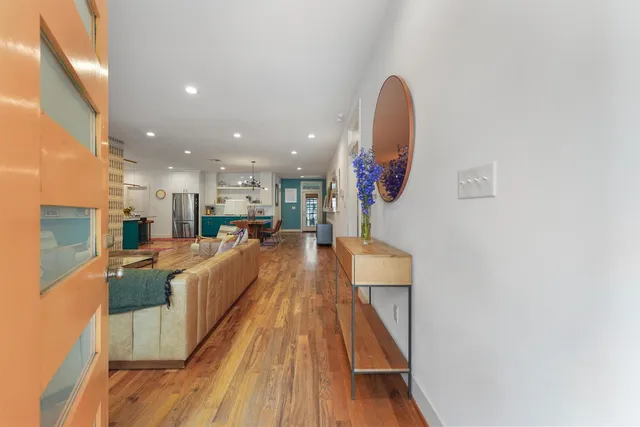 a view of a living room with kitchen and wooden floor