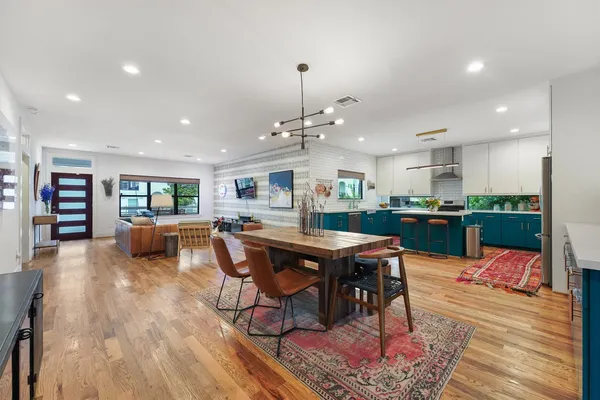 a living room with stainless steel appliances furniture and wooden floor