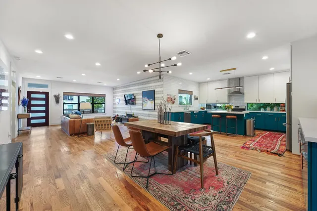 a living room with stainless steel appliances furniture and wooden floor