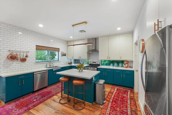 a kitchen with stainless steel appliances granite countertop a refrigerator sink and stove