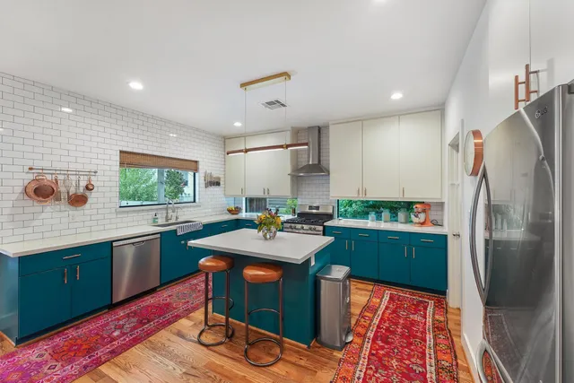 a kitchen with stainless steel appliances granite countertop a refrigerator sink and stove