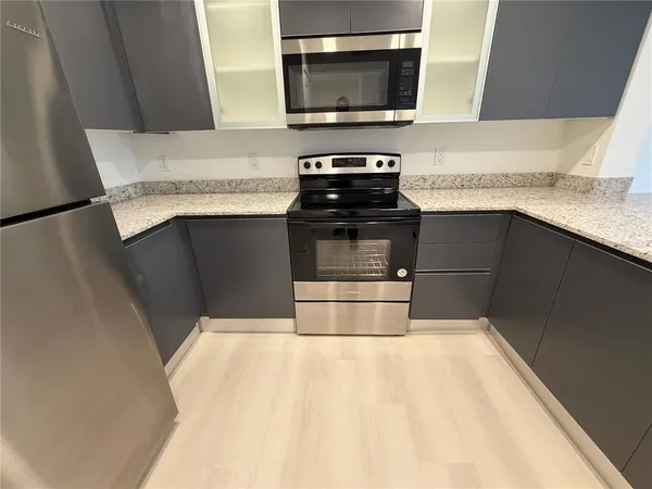 a kitchen with granite countertop a stove and a microwave