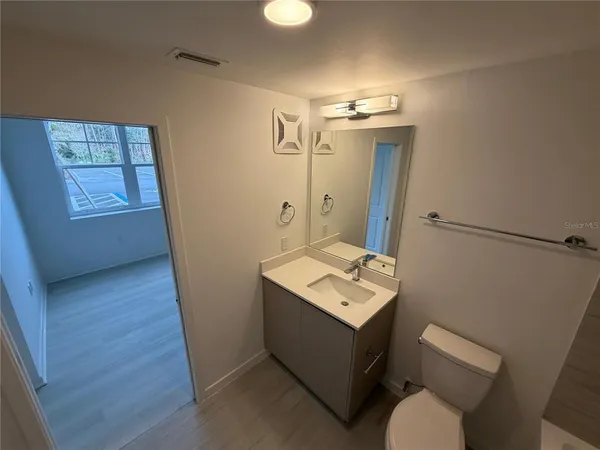 a bathroom with a toilet sink and mirror