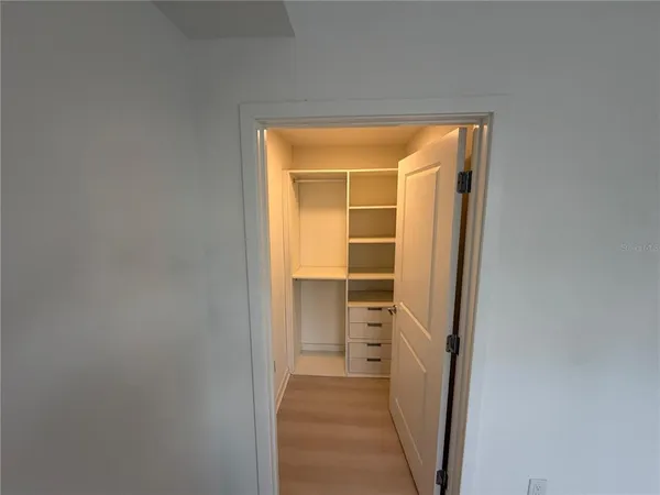 a view of walk in closet with empty racks