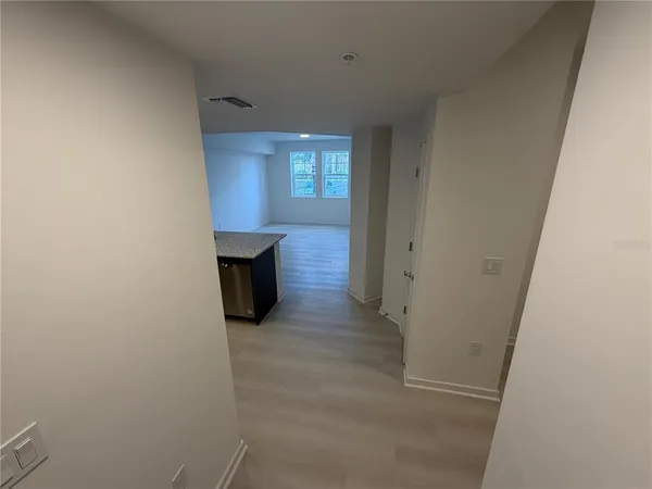 a view of a hallway with wooden floor and fireplace