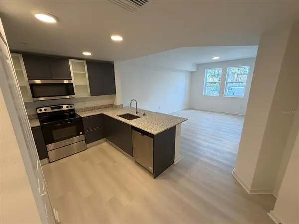 a kitchen with kitchen island stainless steel appliances a sink stove and refrigerator