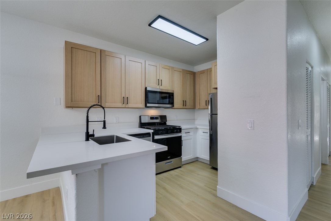 4730 East Craig Road, Unit 1085 Las Vegas, NV 89115 - Photo 7 of 23 A contemporary kitchen features bright white counters and modern appliances, perfect for everyday living.