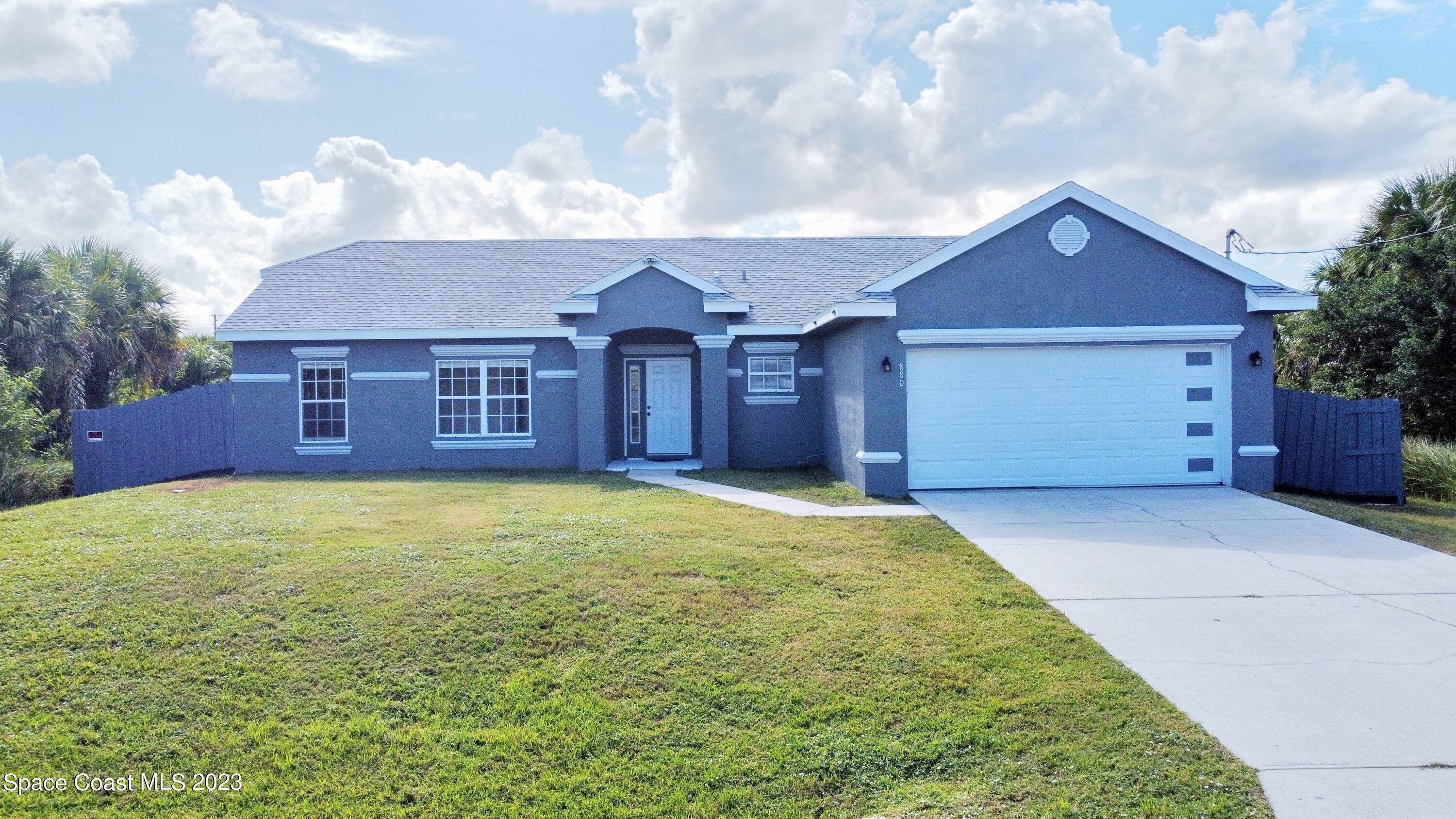880 Kimberly Road Palm Bay, FL 32908 - Photo 1 of 18 a view of a house with a yard and garage