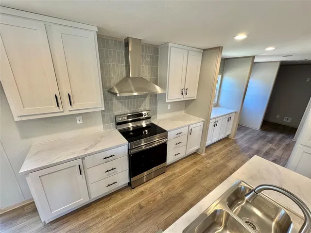 a view of kitchen with wooden floor and electronic appliances