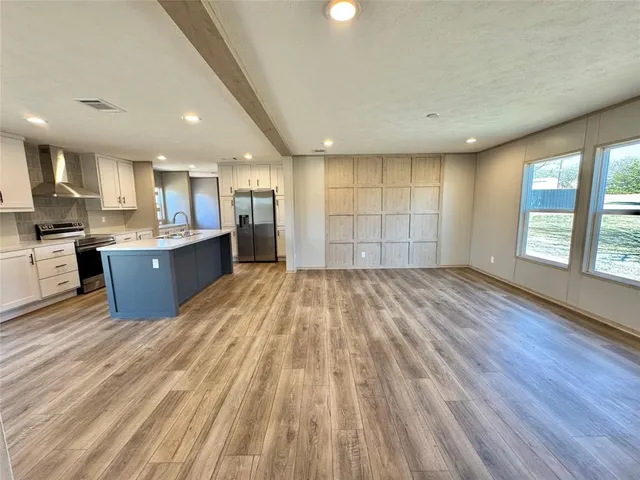 a kitchen with granite countertop white cabinets and wooden floor