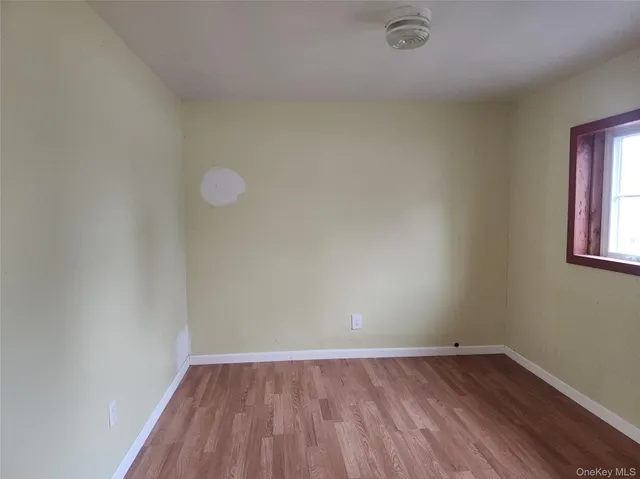 a view of a room with wooden floor and window
