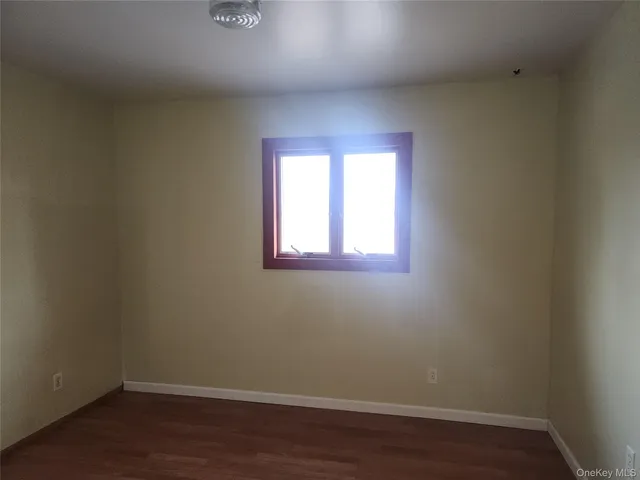 a view of a small space with wooden floor and a window